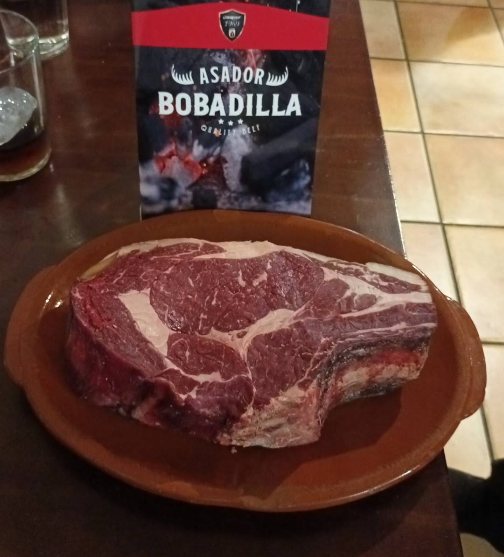 Pieza gruesa de vacuno cruda, muy veteada, en fuente de barro